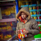 View "Girl holds potato chips outside grocery store"